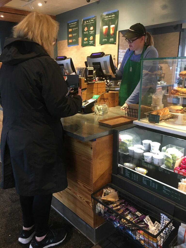 woman-paying-for-her-coffees-the-counter-with-barista-in-starbucks_t20_G0xV23