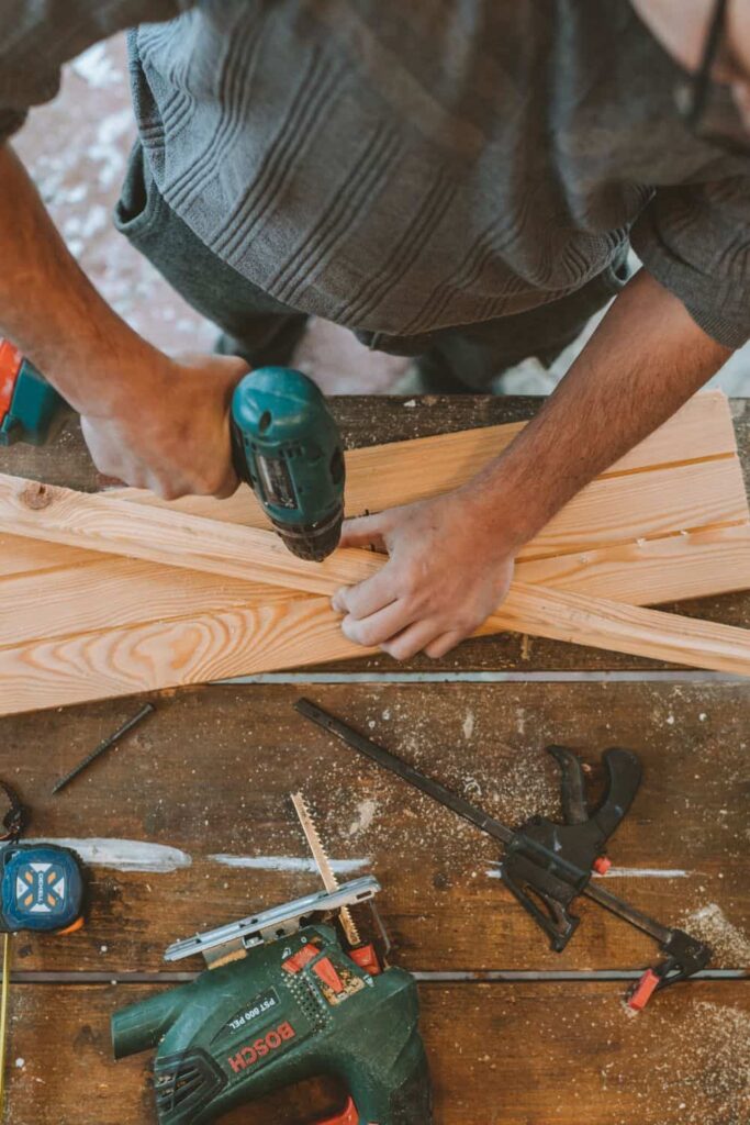 Man drilling holes in wood - Will Home Depot Drill Holes for You?