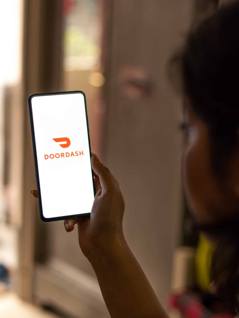 Woman checking doordash - How to Get DoorDash Credits